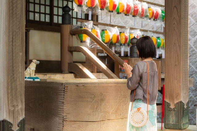 神社で参拝する女性の画像