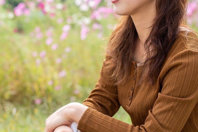 コスモス畑に座る女性